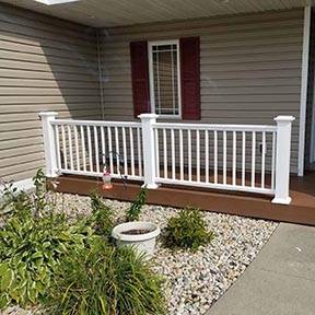 Front porch renovation with wooden white railing 