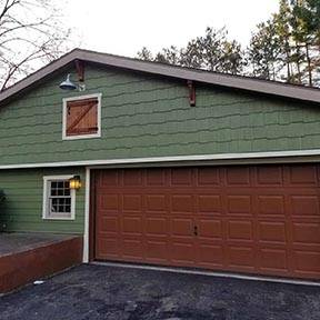 Red and green house with vinyl garage door and green vinyl shingle siding